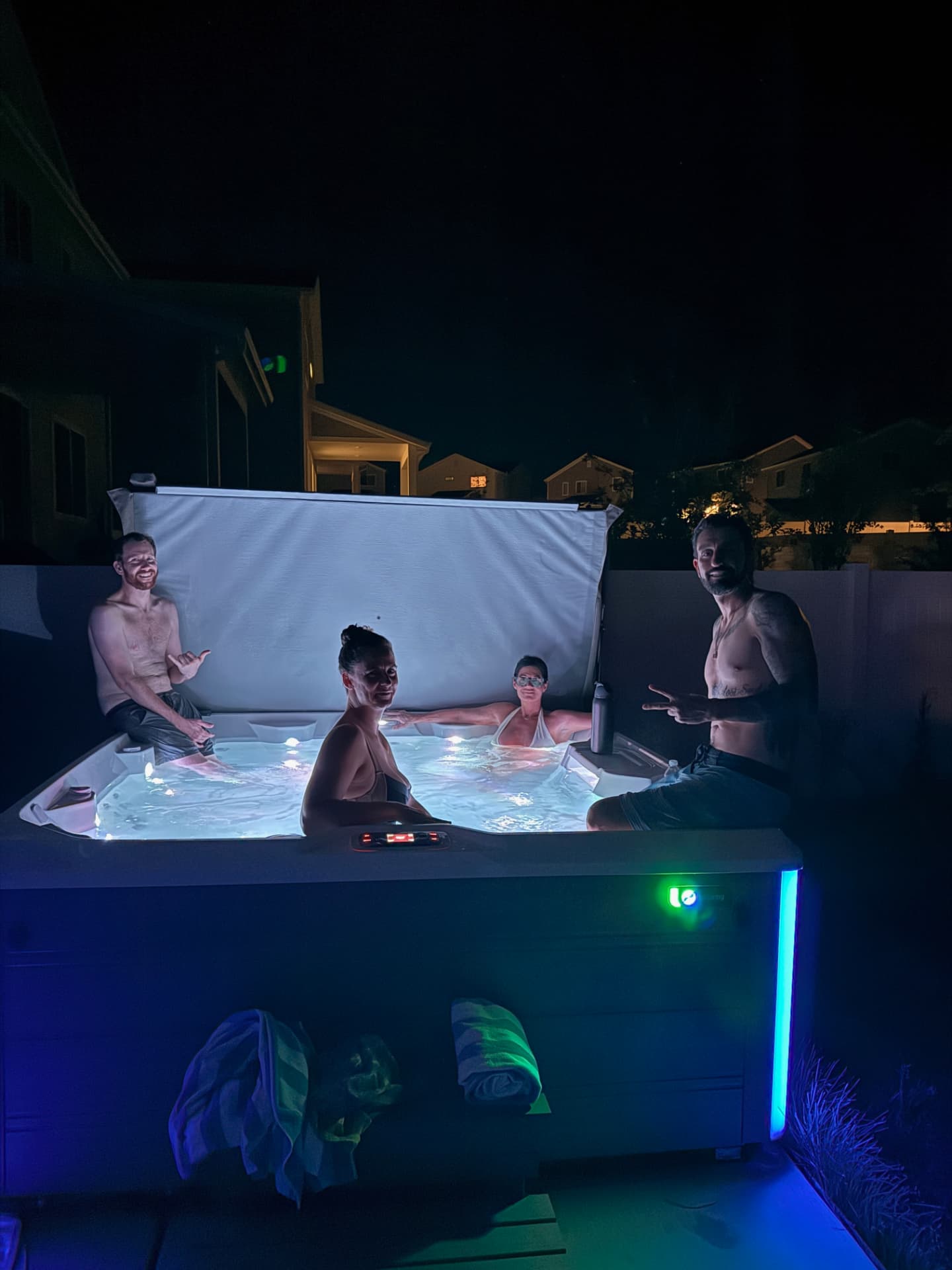 Participants relaxing together in a lit hot tub after dark
